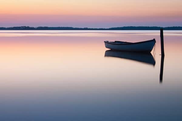 Boat on Calm Still Water at Sunrise